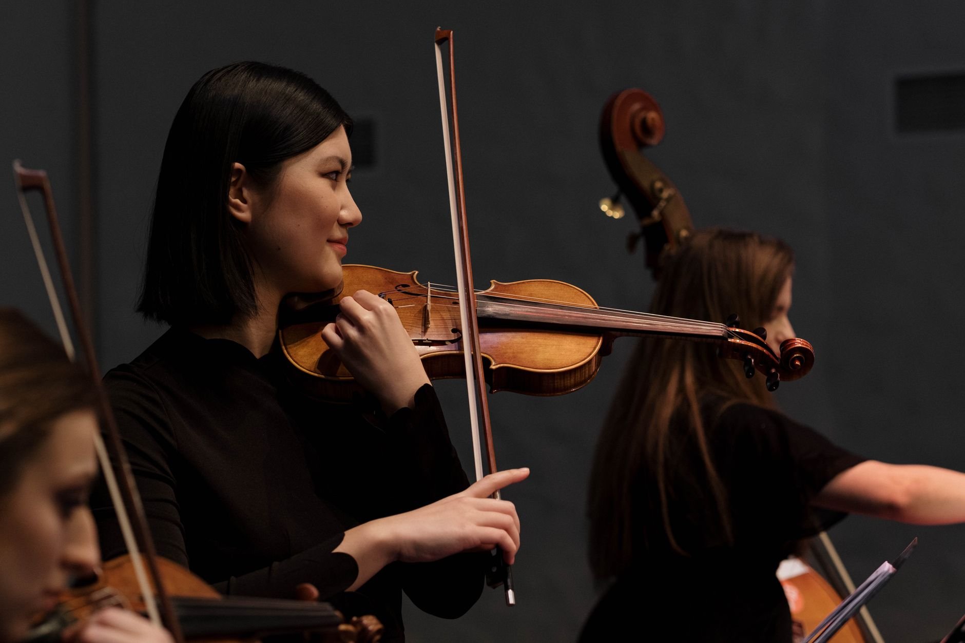 Asian female violinist performing on stage during a live concert
